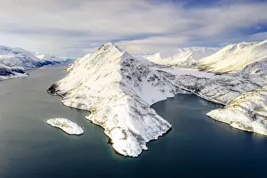 Aerial view of snow capped mountains along the clear water of Altafjord