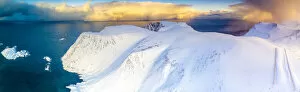 Arctic Gallery: Aerial view of sunrise on snow capped mountains and blue arctic sea, Sorvaer