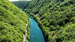 Flowing Prints: Aerial view of Una river winding through green hills in Una National Park in Bosnia and Herzegovina