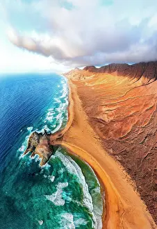 Dunes Prints: Aerial view of volcanic cliffs overlooking Cofete beach washed by waves