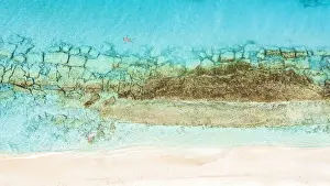 Mid Adults Prints: Aerial view of woman floating on the crystal sea in between coral reef and white sand beach