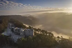 Aerial vista of Castle Drogo and the Teign Valley in morning mist in winter, Dartmoor