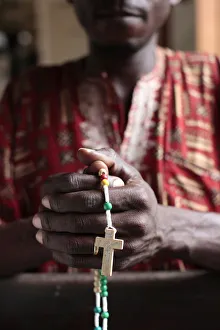 Benin Prints: African man praying the rosary, Cotonou, Benin, West Africa, Africa