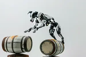 Hobby Prints: AI generated image of a Dog robot jumping over barrels in front of a white background