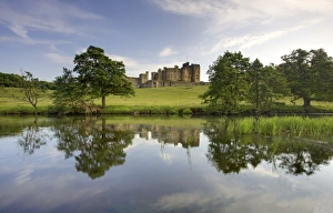 Alnwick Castle reflecting in River Aln, Alnwick, Northumberland, England