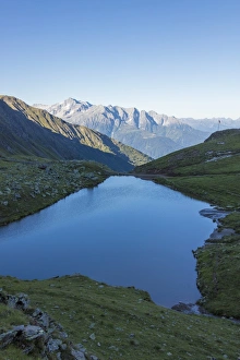 Brescia Prints: The alpine lake frames the green valley and Rifugio Bozzi, Val Di Viso, Camonica Valley
