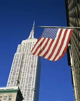 Sky Scrapers Prints: The American flag, the stars and stripes in front of the Empire State Building in New York