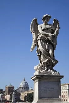 Angel statue on Ponte Sant Angelo (Bridge of Angels), with the dome of the Vatican in distance