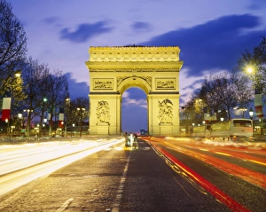 The Arc de Triomphe illuminated at dusk, Paris, France