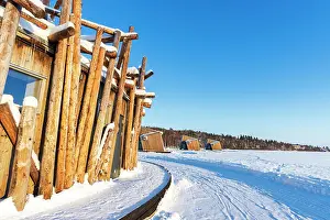 Architectural structure of Arctic Bath hotel made of logs on frozen Lule River with cutting-edge chalets in the background, Harads, Norrbotten, Swedish Lapland, Sweden, Scandinavia, Europe