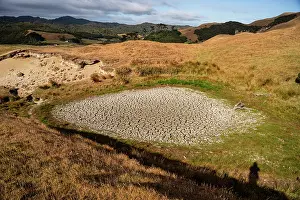Zealand Prints: Arid farmland with dried pond and golden grass hills during summer drought in New Zealand
