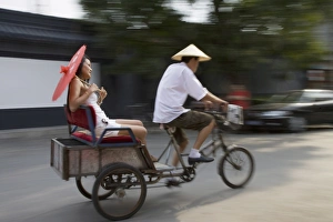 Rick Shaw Prints: Asian woman (Chinese-Thai) riding in cycle rickshaw, Hutong District, Beijing