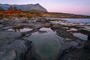 Hidden Prints: Aspes beach, natural holes in the rocks full of water at sunset
