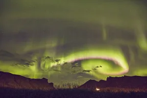 The Aurora Borealis (Northern Lights), seen in the night sky above Vik