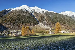 Engadine Prints: Autumn colors frame the village of Zernez surrounded by woods and snowy peaks, Engadine
