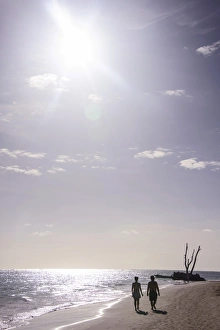 Bavaro Prints: Backlit tourists walking on the beach of Bavaro
