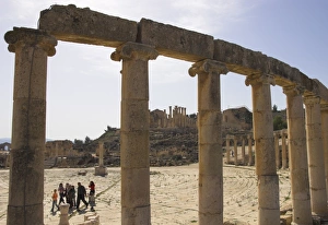 Jerash Prints: Backlit view through columns with family walking past