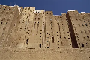 Yemen Prints: Backs of tall mud brick houses showing holes in the wall for toilets