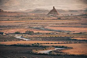 Navarre Prints: The badlands of Bardenas Reales at sunrise with a winding road leading towards the Castildetierra rock formation