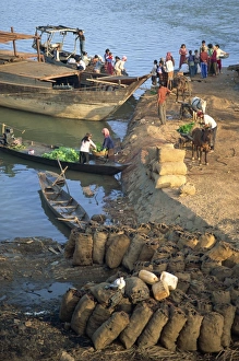 Coal Prints: Bags of coal on the shore and boats in the background at Stung Treng, Cambodia