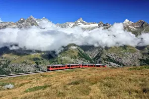 Meadow Prints: The Bahn train on its route with high peaks and mountain range in the background