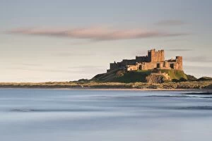 Images Dated 11th September 2010: Bamburgh Castle bathed in golden evening light overlooking Bamburgh Bay with the sea filling