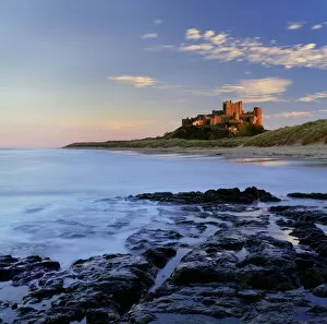 Sun Rise Collection: Bamburgh Castle bathed in warm evening light, Bamburgh, Northumberland