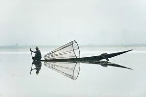 Images Dated 5th April 2010: A basket fisherman on Inle Lake scans the still and shallow water for signs of life