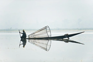 Images Dated 5th April 2010: A basket fisherman on Inle Lake scans the still and shallow water for signs of life