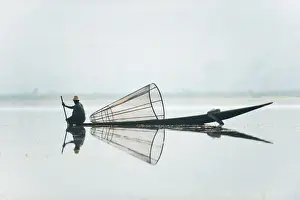 Fisherman Prints: A basket fisherman on Inle Lake scans the still and shallow water for signs of life