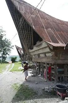 Lake Toba Prints: Batak woman carrying skeins of yarn to the looms under her traditional Batak house