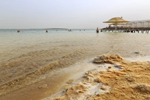 Dead Sea Prints: Bathers in the Dead Sea, with salty shoreline, Ein Bokek (En Boqeq) beach, Israel