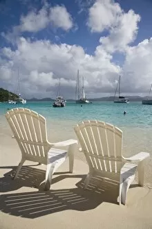 Two empty beach chairs on sandy beach on the island of Jost Van Dyck in the British Virgin Islands