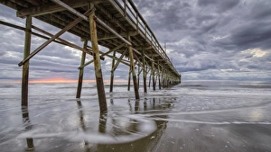 Beach, ocean, waves and pier at sunrise, Sunset Beach, North Carolina, United States of America