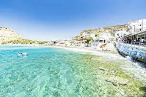 Beach of the seaside town resort of Matala washed by turquoise sea, Crete, Greek Islands