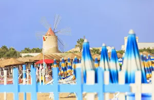 Contrast Collection: Beach umbrellas and windmill, Baia dei Mulini, Trapani, Sicily, Italy, Mediterranean