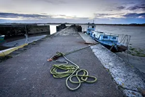 Rope Prints: Beadnell Harbour at dusk showing old rope coiled on harbourside and dilapidated fishing boat