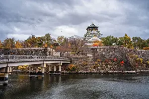 Historical Site Prints: Beautiful Osaka Castle moat in autumn (fall) with bridge leading over the waters towards the Samurai Castle