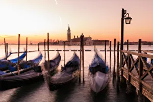 Beautiful Venetian sunrise in winter, gondolas, San Giorgio Maggiore and Lido, Venice