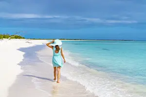 Mid Adults Prints: Beautiful woman walking on idyllic beach washed by Caribbean Sea
