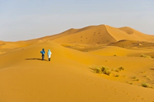 Erg Chebbi Prints: Two Berber men walking in the sand dunes of Erg Chebbi Desert
