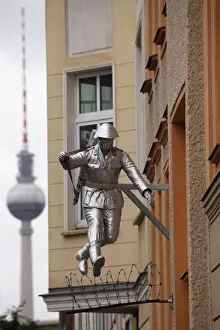 Soldier Prints: Berlin Television Tower (Fernsehturm) and sculpture of a soldier jumping the Berlin Wall at Bernauerstrasse