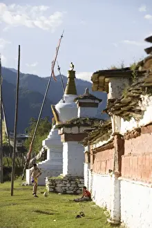 Bhutan Prints: Bhutanese boys playing soccer near Buddhist chortens (stupa), Paro, Bhutan, Asia