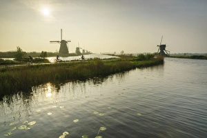 South Holland Prints: Bicycles run through a path between the canal and windmills, Kinderdijk, Rotterdam