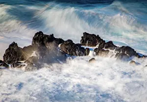 Foam Prints: Big waves crash over rocks in Porto Moniz Madeira during a windy day while the ocean swells and breaks around the shore