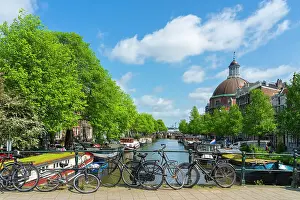 Cruising Prints: Bikes on Corsgenbrug bridge over Singel canal and Renaissance dome of Koepelkerk Church in the background