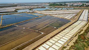 Land Prints: Birds-eye view of saltpans showing lines of water and salt preparation in a coastal area located in Algarve