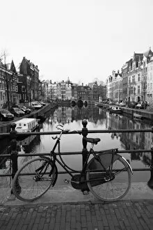 Black and white image of an old bicycle by the Singel canal, Amsterdam