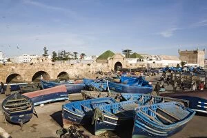 Blue boats in fishing port outside fortified town walls on west coast, Essaouira