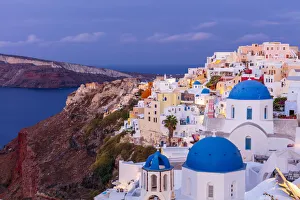 Santorini Gallery: Blue domed white church and colourful buildings at sunrise, Oia, Santorini, Cyclades